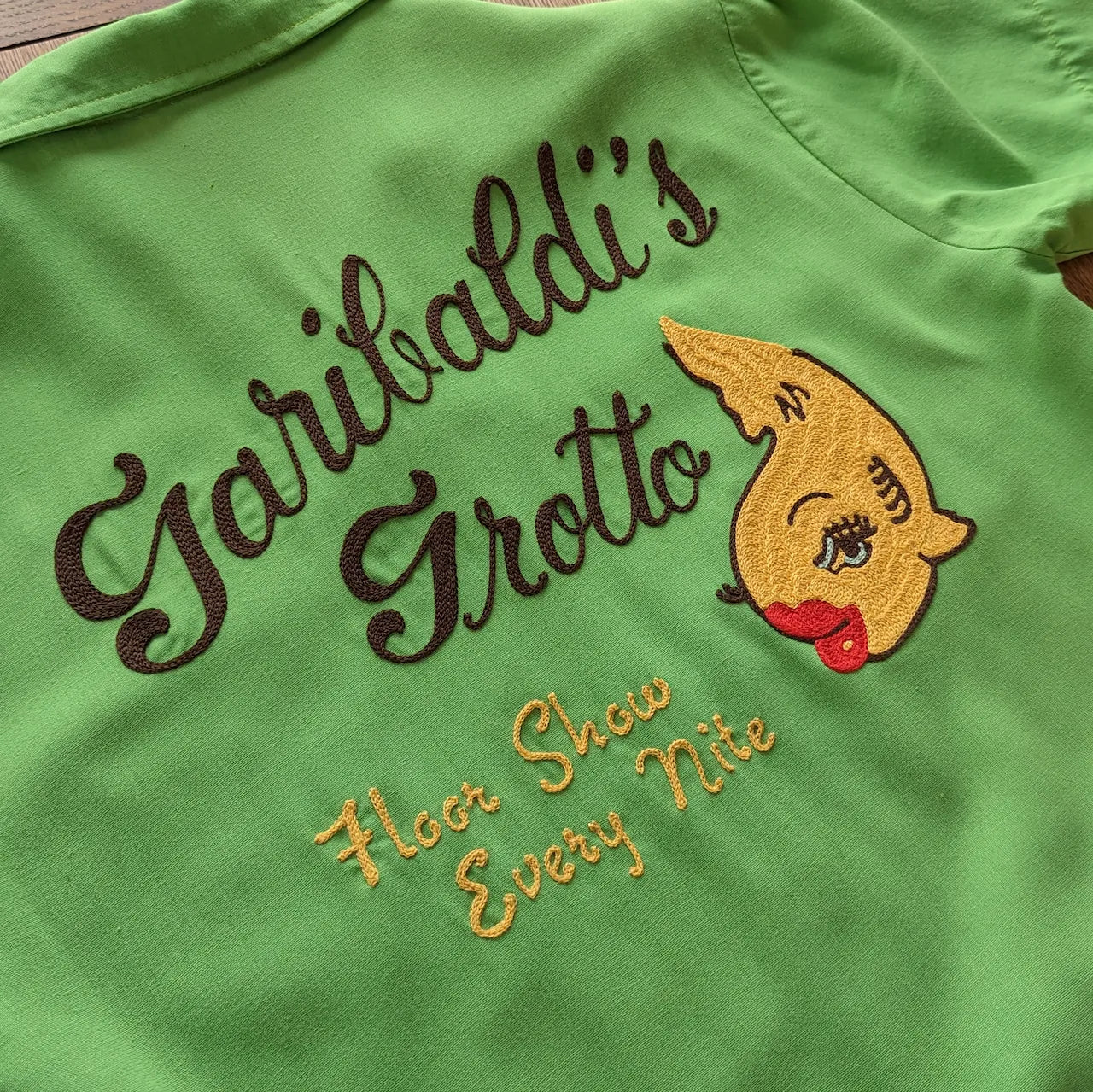 Green shirt with chainstitch embroidery. The design and lettering reminiscent of mid-century matchbooks.