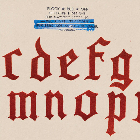 Vintage-style letterpress typeface with red letters on a beige background, featuring text at the top.